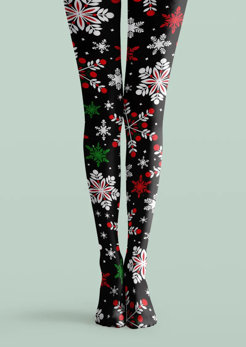 Black printed tights with white and red snowflakes, leafy sprigs, berries, and small green accents