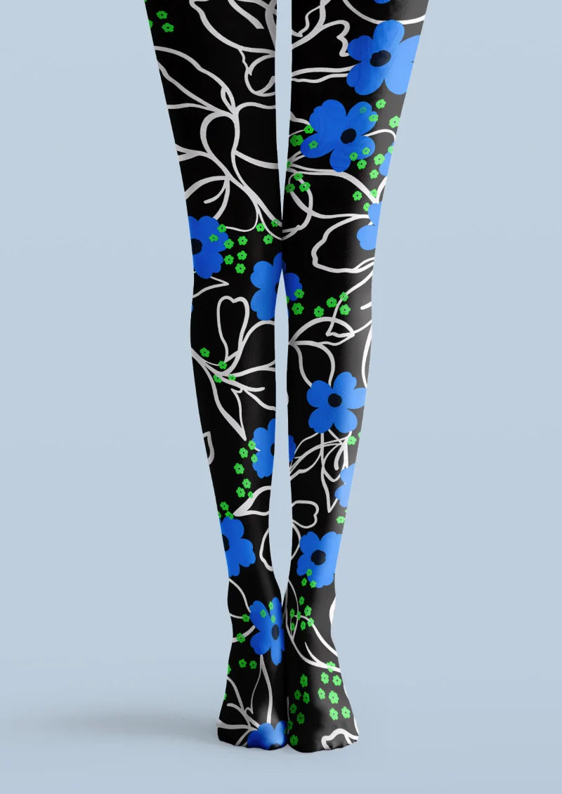 Black printed tights with blue flowers, white botanical outlines, and small bright green floral accents.
