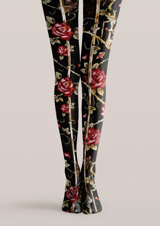 Black printed tights with red roses, brown thorny stems, shaded leaves, and scattered red petals along both legs.