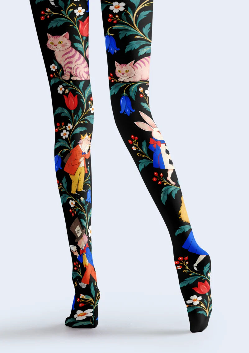 Black tights with pink striped cats, a white rabbit, illustrated characters, teal leaves, and colorful flowers
