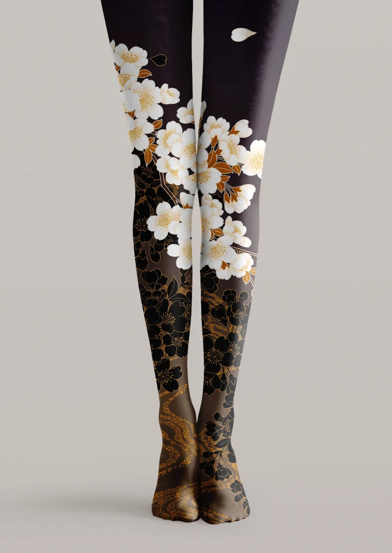 Black printed tights with white blossoms and bronze botanical linework arranged across both legs