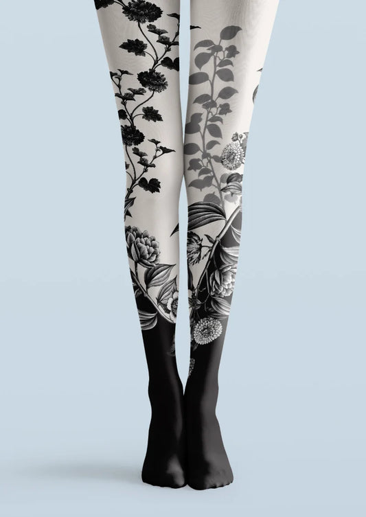 Black and white printed tights with black botanical floral motifs and a dark lower-leg finish.