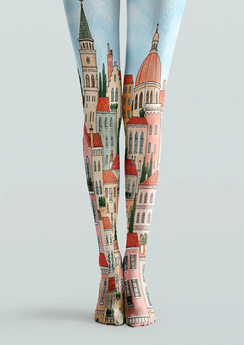 Beige and pink cityscape printed tights with towers, a domed building, tiled rooftops, green trees and a pale blue sky.