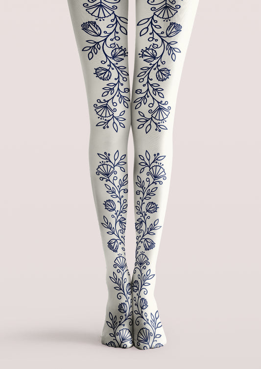 Ivory printed tights with navy floral vines, leaves, buds, and stylized flowers arranged vertically along both legs.