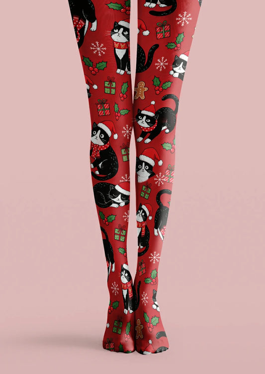 Red printed tights with black and white cats in Santa hats, scarves, gifts, holly, snowflakes and gingerbread figures.