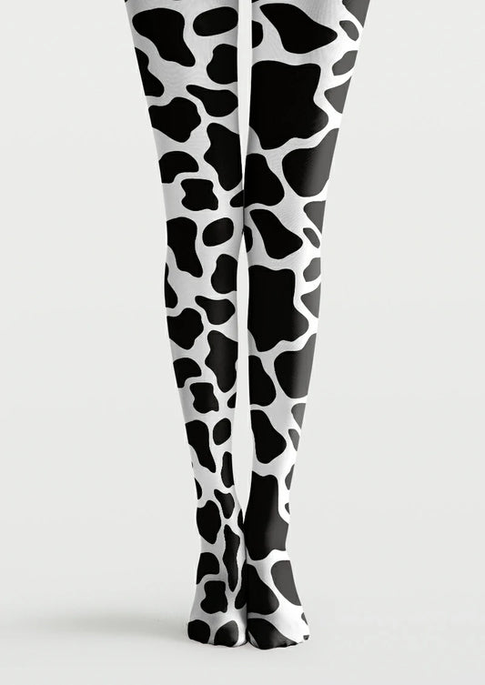 Black and white printed tights with large irregular cow patches and smaller rounded markings across both legs and feet.