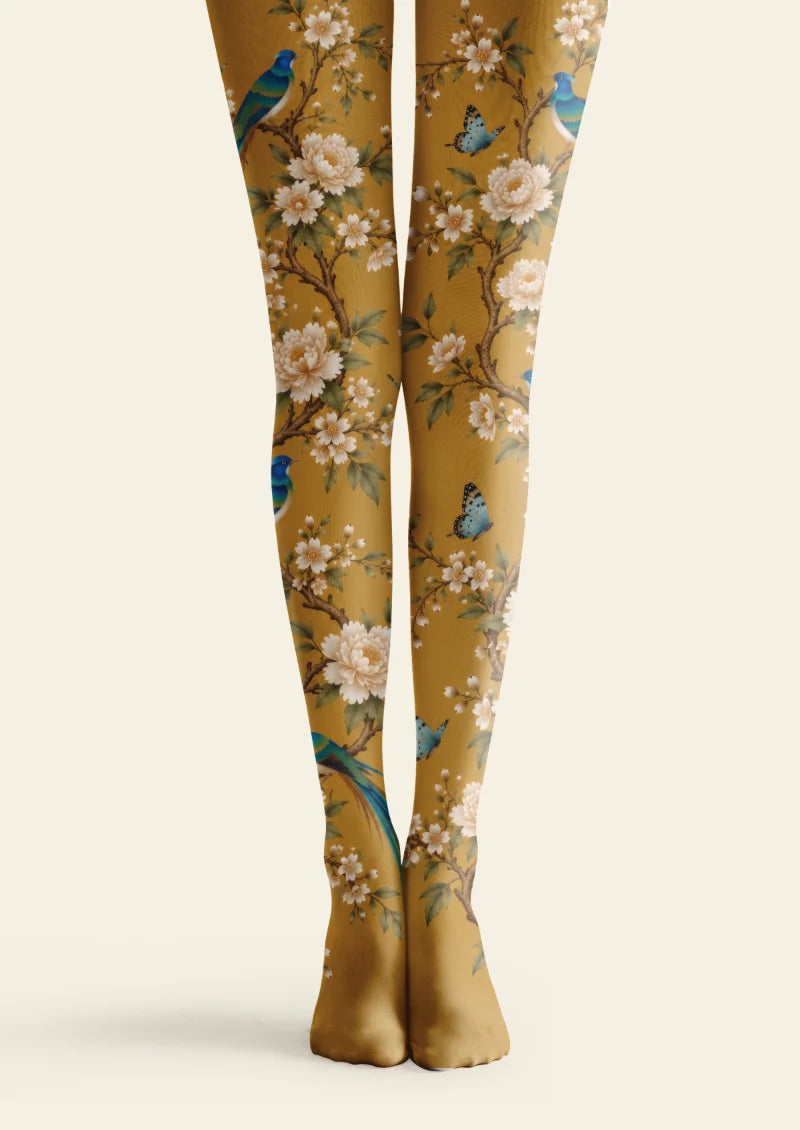 Yellow tights with ivory blossoms, brown branches, green leaves, blue birds, and blue butterflies