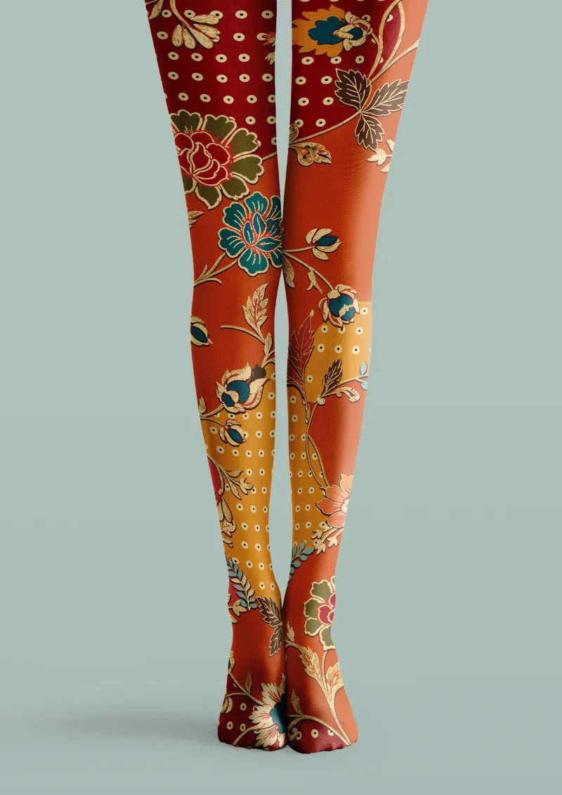Red and orange printed tights with teal, green, and cream floral motifs and scattered circular details