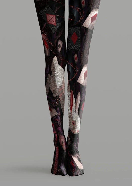 Black printed tights with a large white rabbit, red and black playing card symbols, mushrooms and purple foliage.