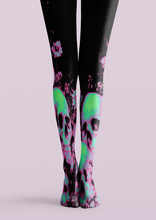 Black printed tights with neon green skulls, pink flowers, and vivid graphic accents across both legs.