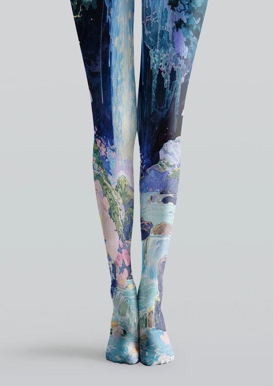 Blue printed tights with waterfall landscape, aqua water, dark blue sky, rocks, green foliage, and pink flowers