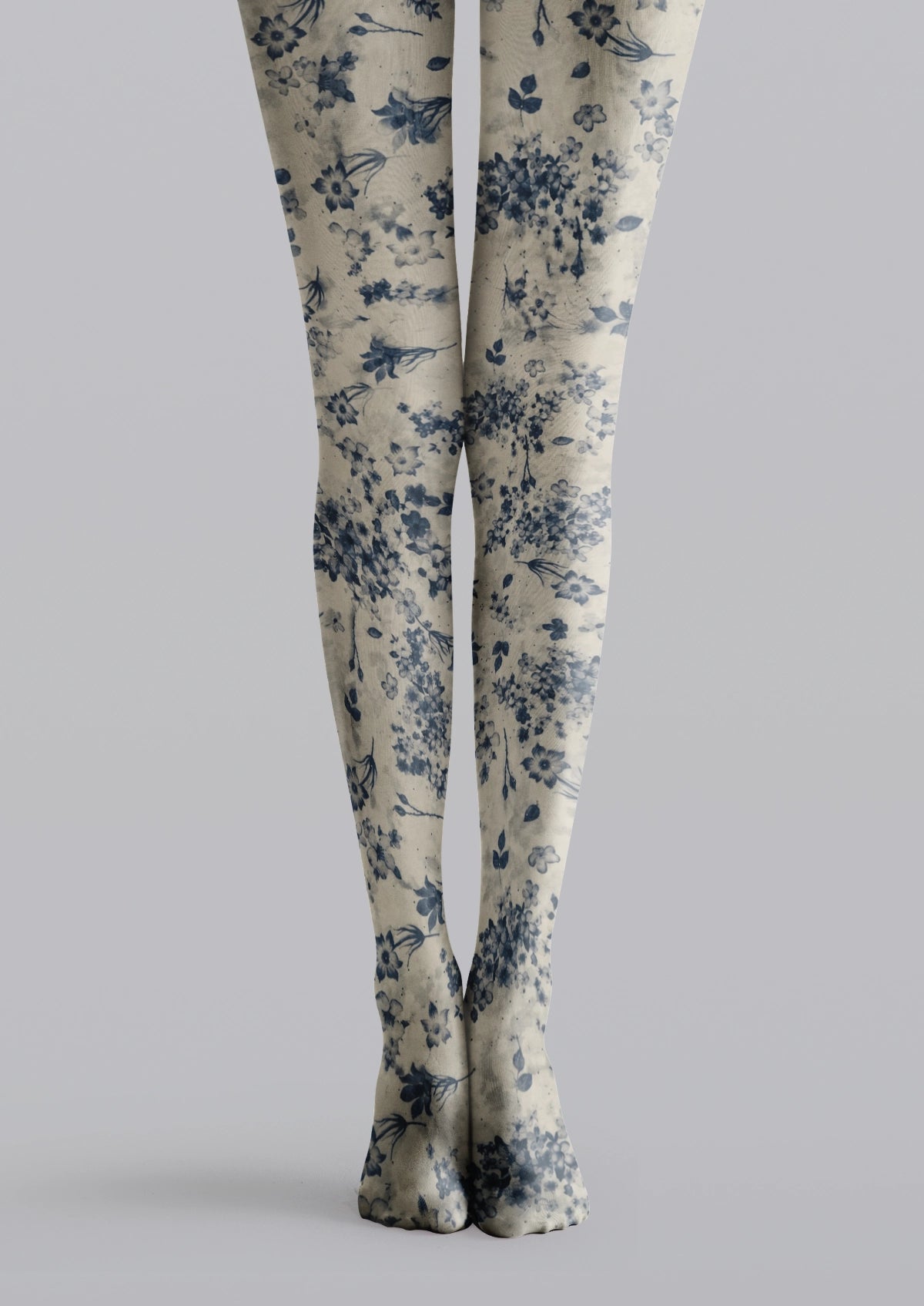 Beige printed tights with navy blue flowers, scattered blue blossoms, and delicate leafy details.