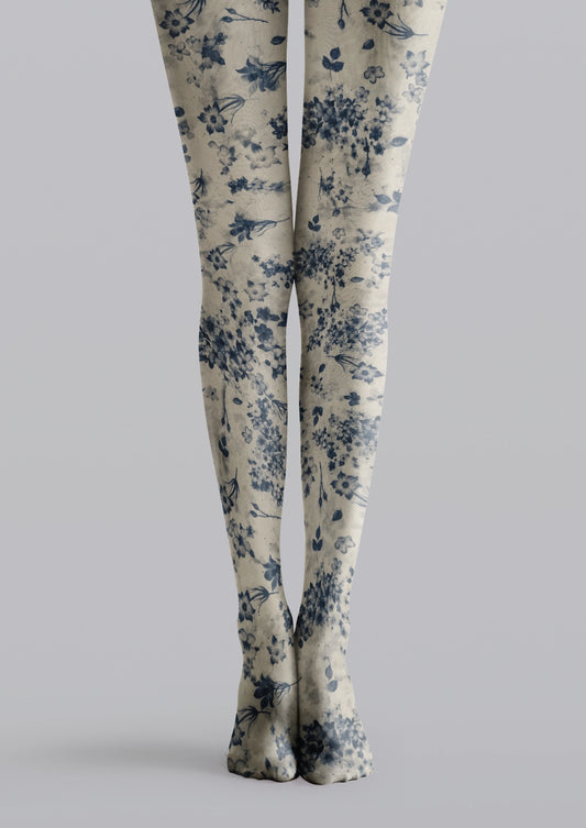 Beige printed tights with navy blue flowers, scattered blue blossoms, and delicate leafy details.