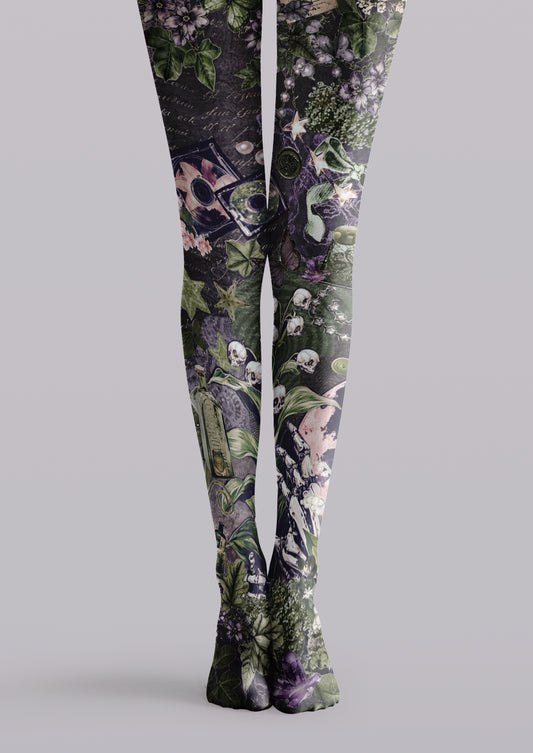 Black printed tights with green ivy, purple flowers, skulls, skeletal figures, stars, and gothic collage motifs