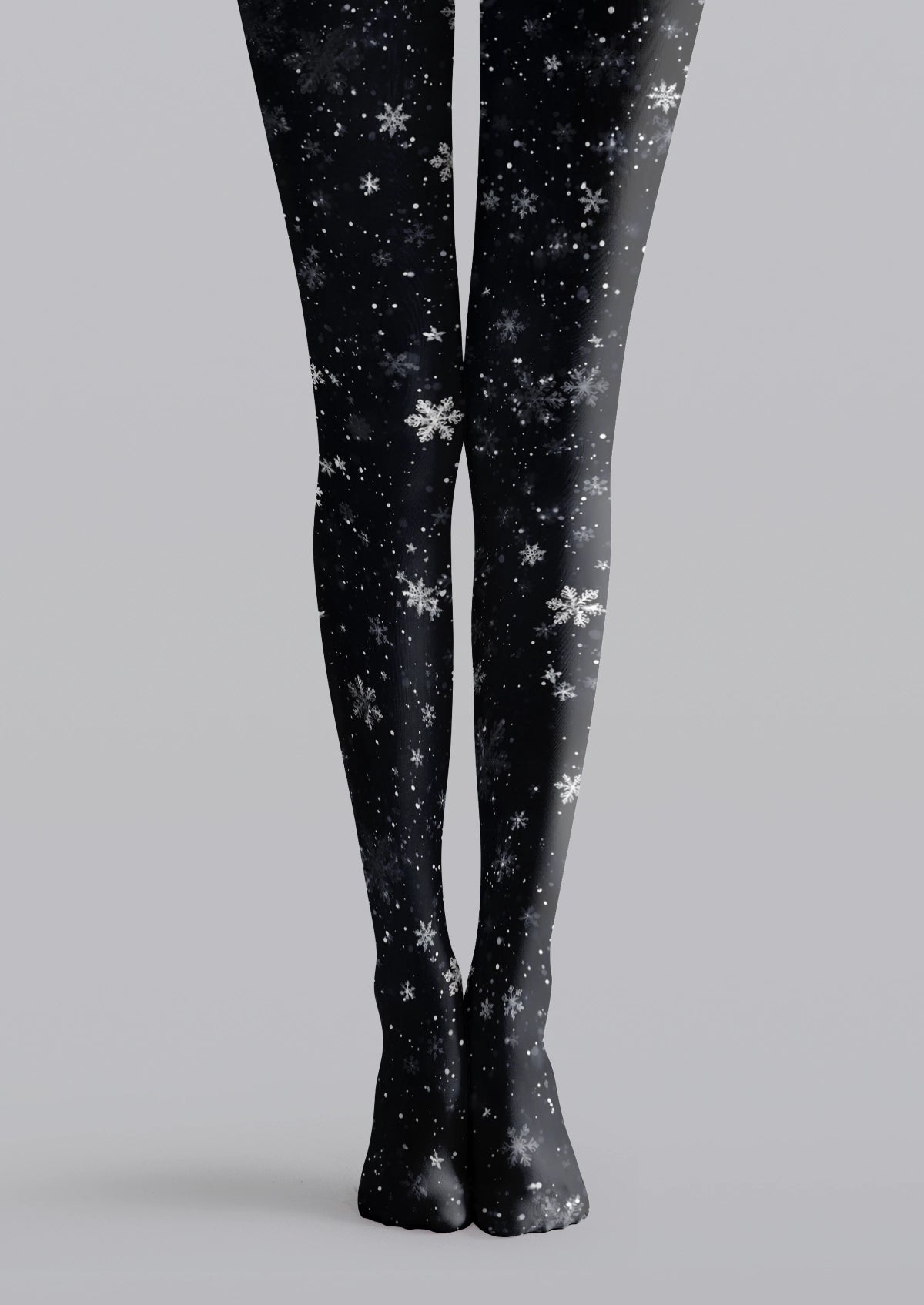 Black printed tights with white and gray snowflakes and scattered snow-like dots across both legs.