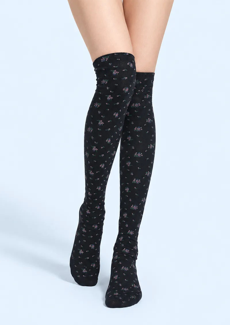 Black printed knee stockings with small pink and green ditsy floral motifs in an allover pattern.