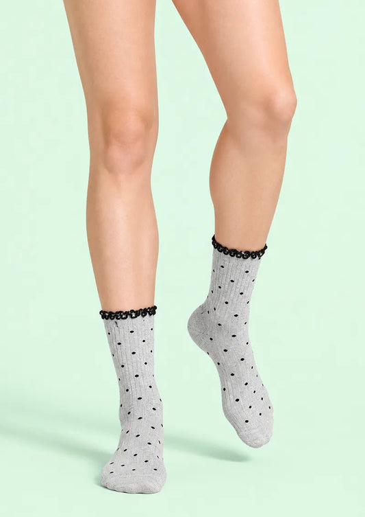 Front view of gray Crew Socks with black polka dots, ribbed texture, and a black ruffled cuff