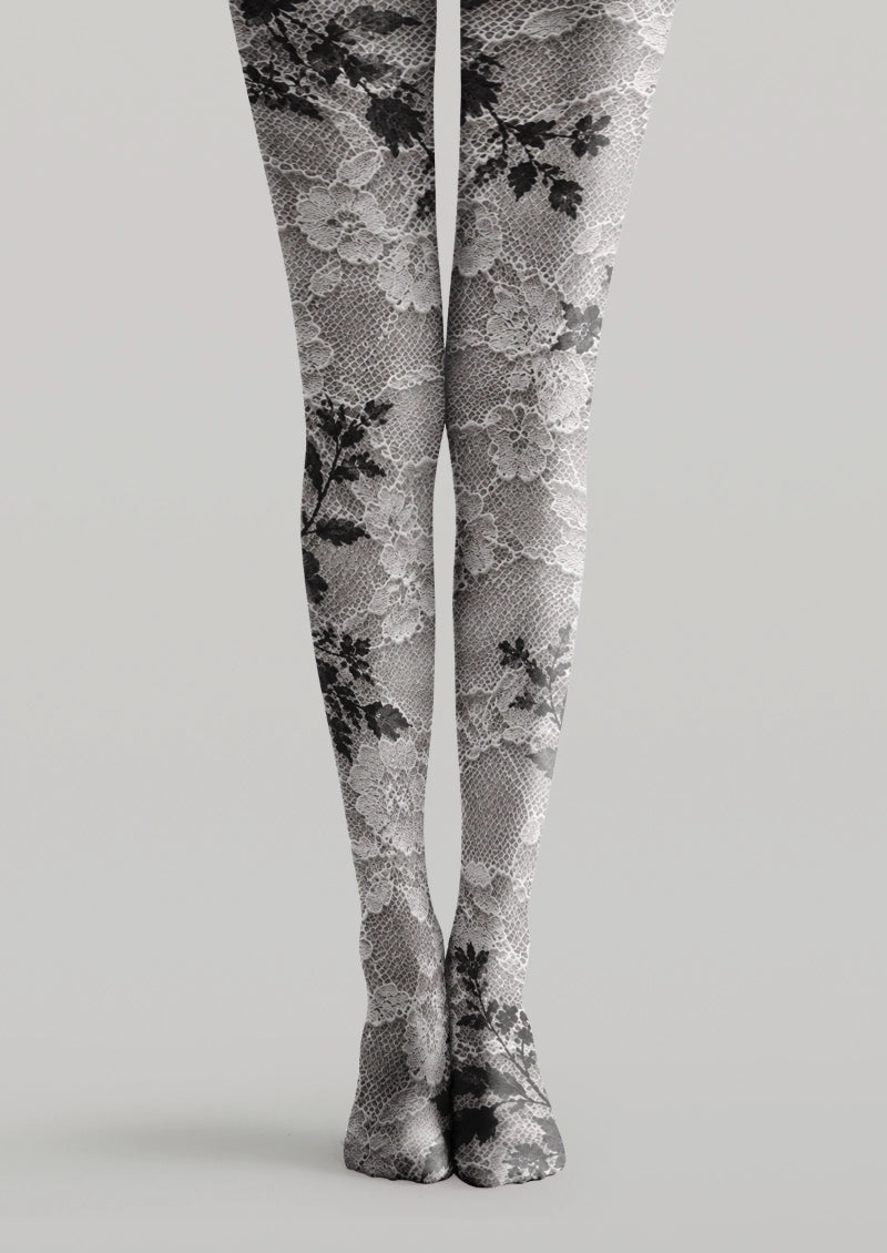 White printed tights with black floral motifs and an intricate net-like pattern.