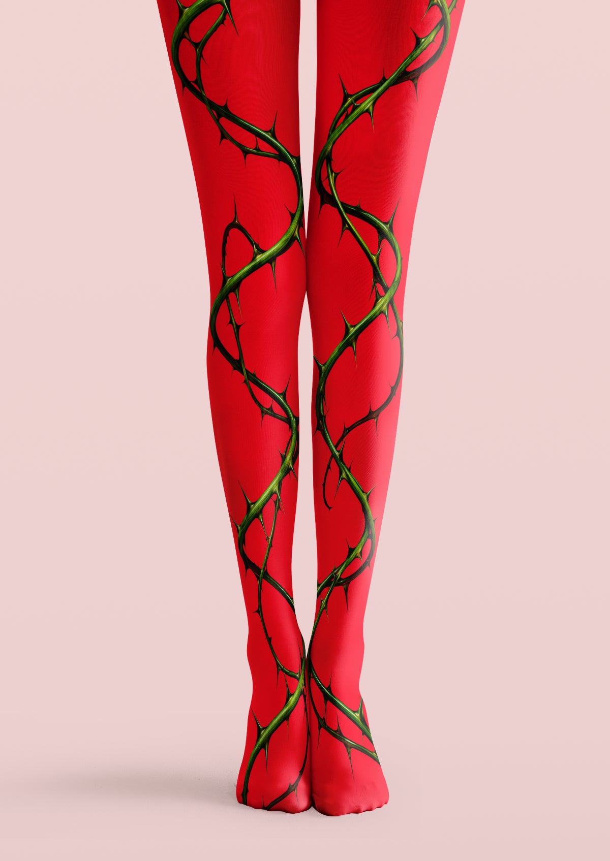 Red printed tights with winding green thorn vines and black detailing extending down both legs onto the feet