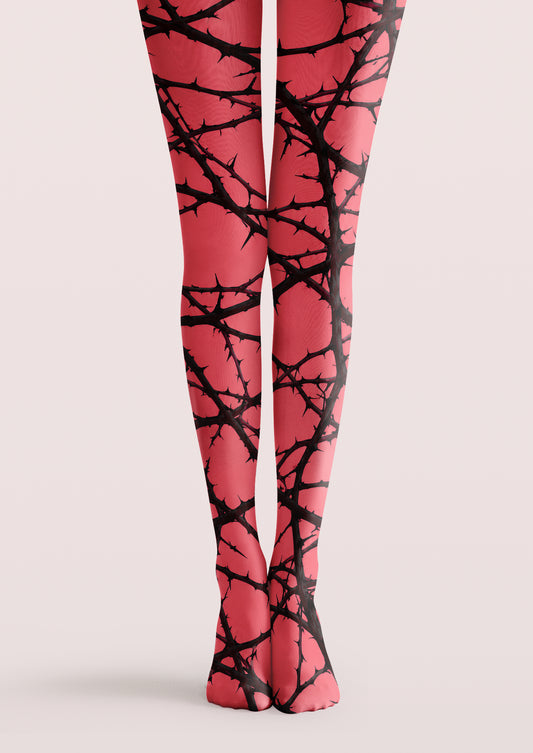 Pink printed tights with intersecting black thorn branches across both legs, ankles, and feet