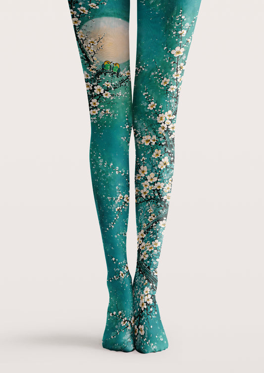 Green printed tights with white plum blossoms, branches, and bird nature pattern details.